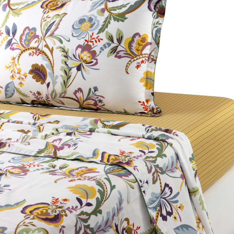 Un drap blanc à motifs floraux colorés jaunes, bleus et violets, associé à un drap texturé jaune uni.