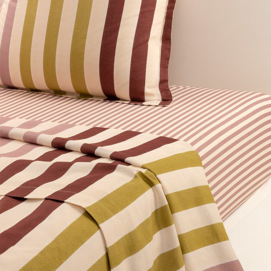 Un lit avec des draps et des oreillers rayés