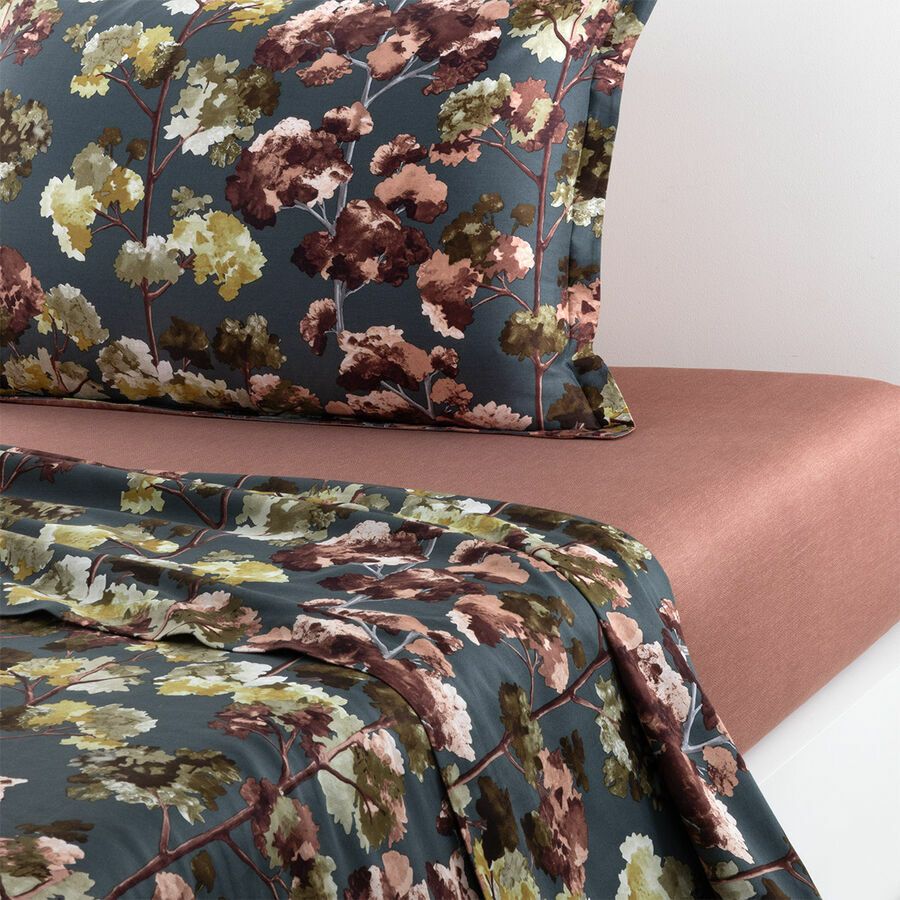 Floral print duvet cover and pillow on a dusty rose bedsheet.
