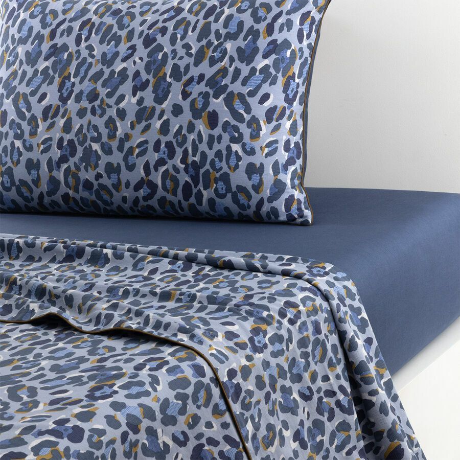 Parure de lit à imprimé léopard bleu sur un lit bleu.