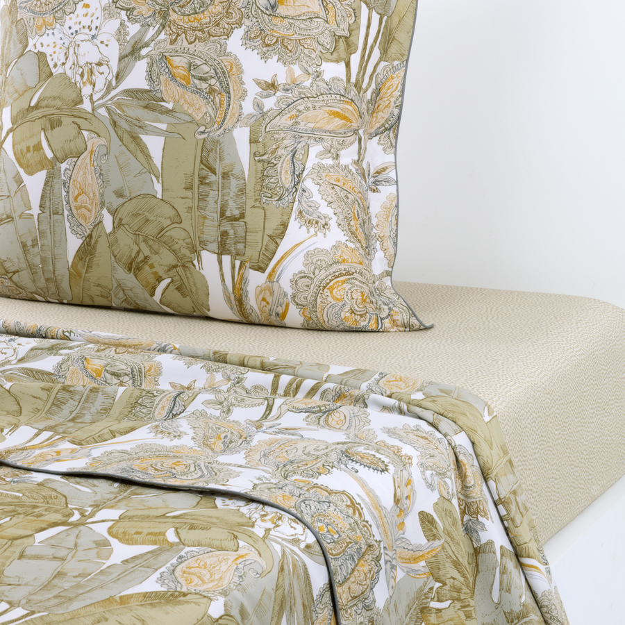 Un lit avec une couette fleurie et des oreillers dessus