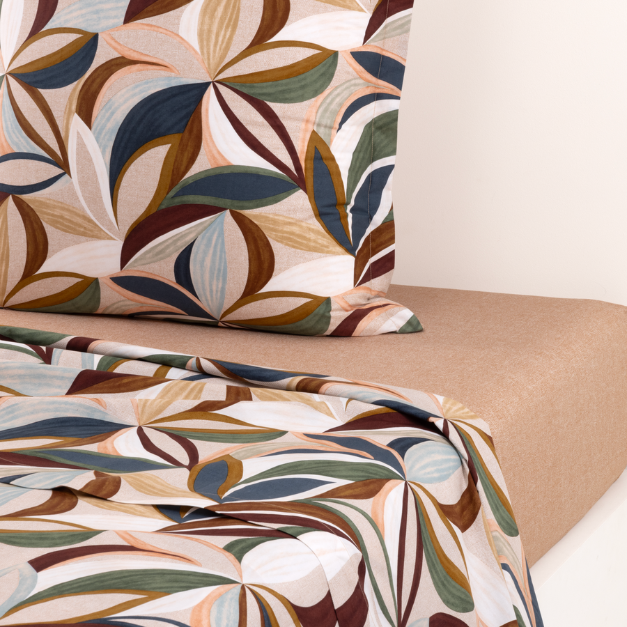 Un lit avec une couette fleurie et des oreillers dessus