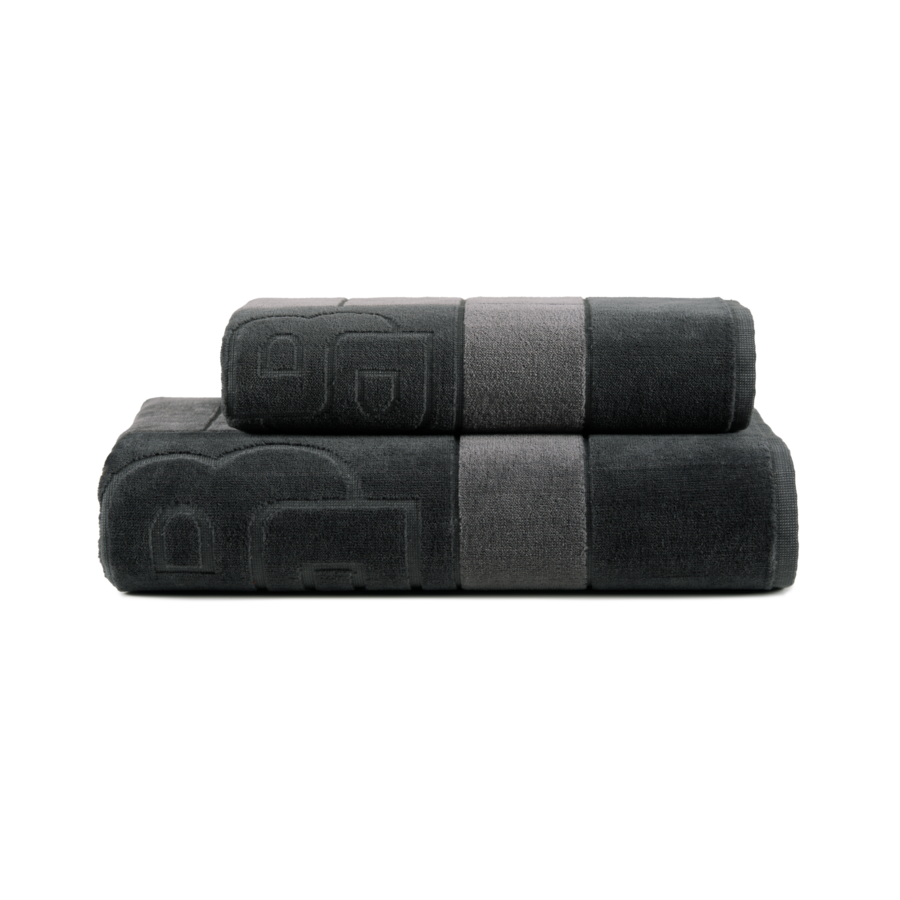 Deux serviettes noires empilées l'une sur l'autre sur un fond blanc