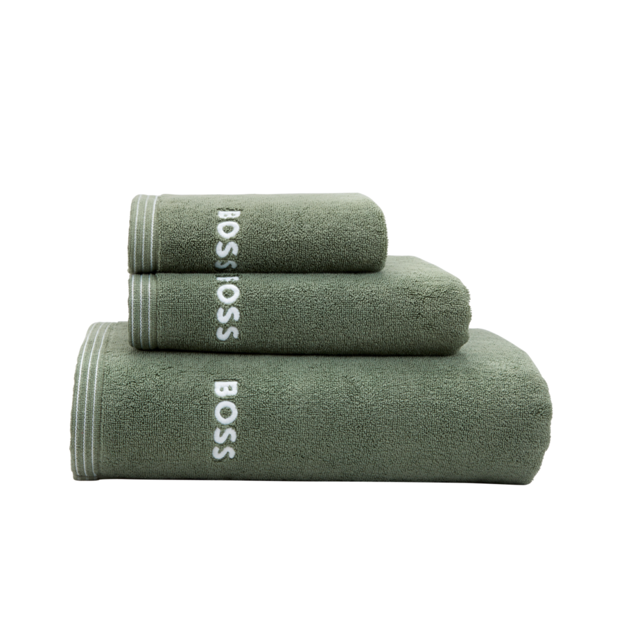Une pile de trois serviettes en coton vert sauge, chacune ornée du logo BOSS blanc brodé près du bord rayé.