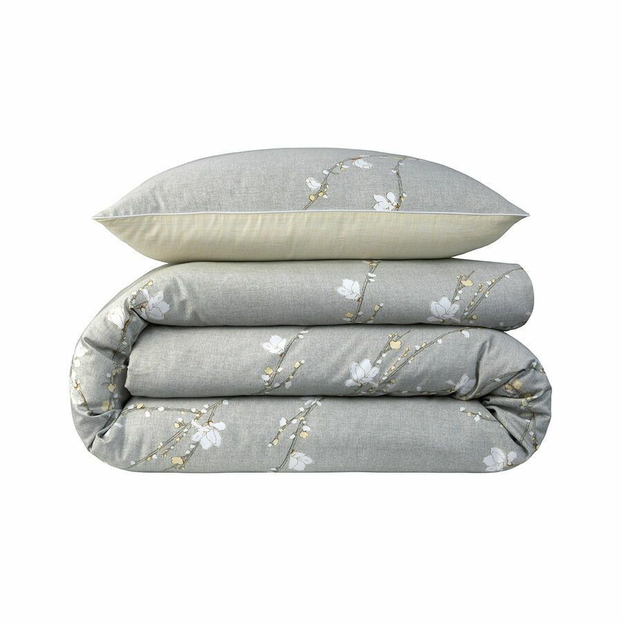 Une couette grise et deux oreillers empilés l'un sur l'autre