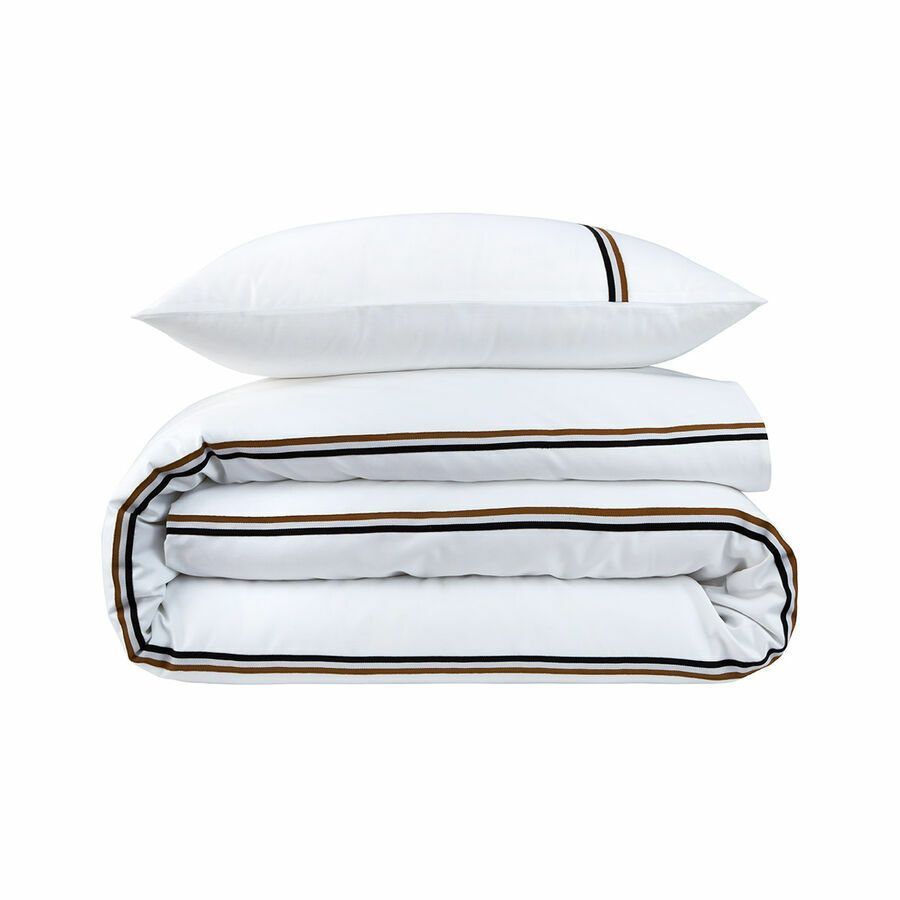 Une couette blanche et deux oreillers sont empilés l'un sur l'autre.