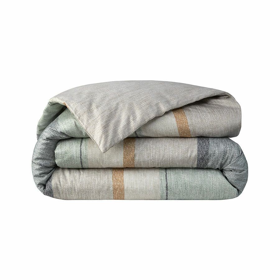 Une couverture avec un motif à carreaux est empilée les unes sur les autres sur un fond blanc.