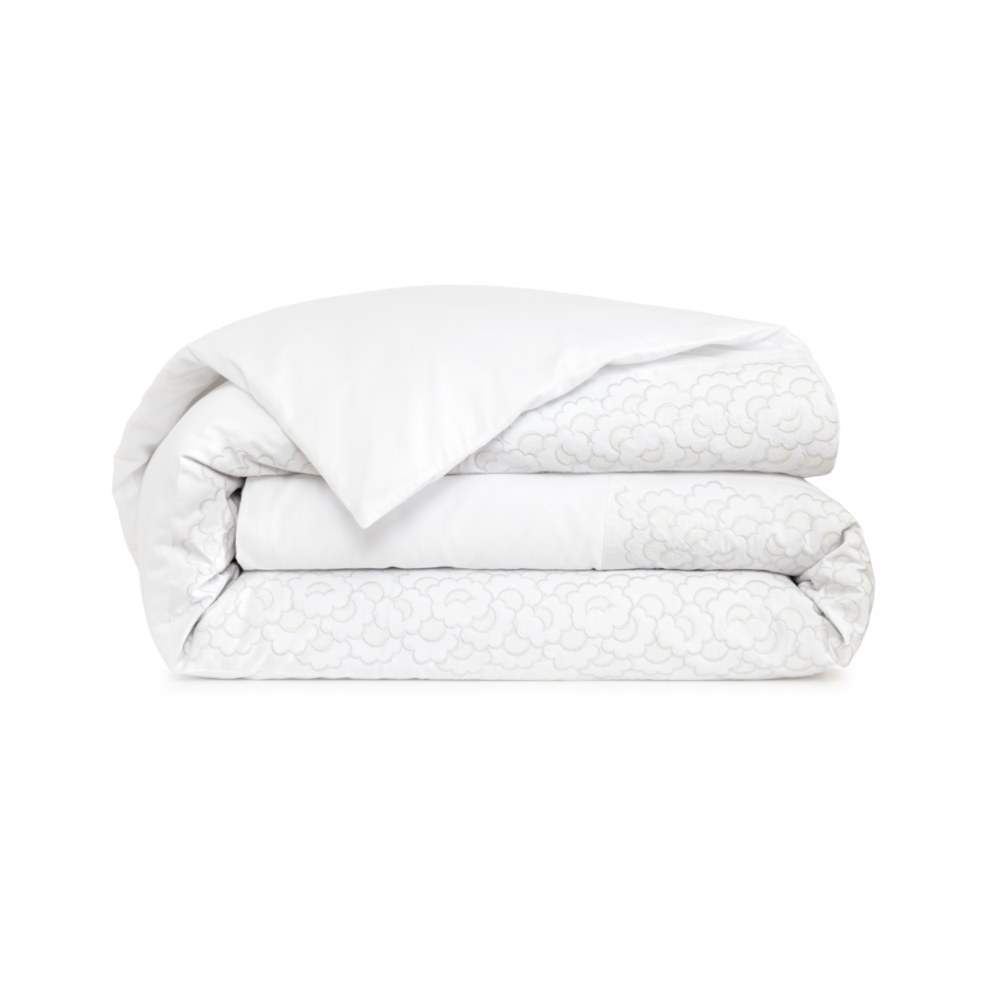 Ensemble de couette blanche pliée avec détails à motifs.