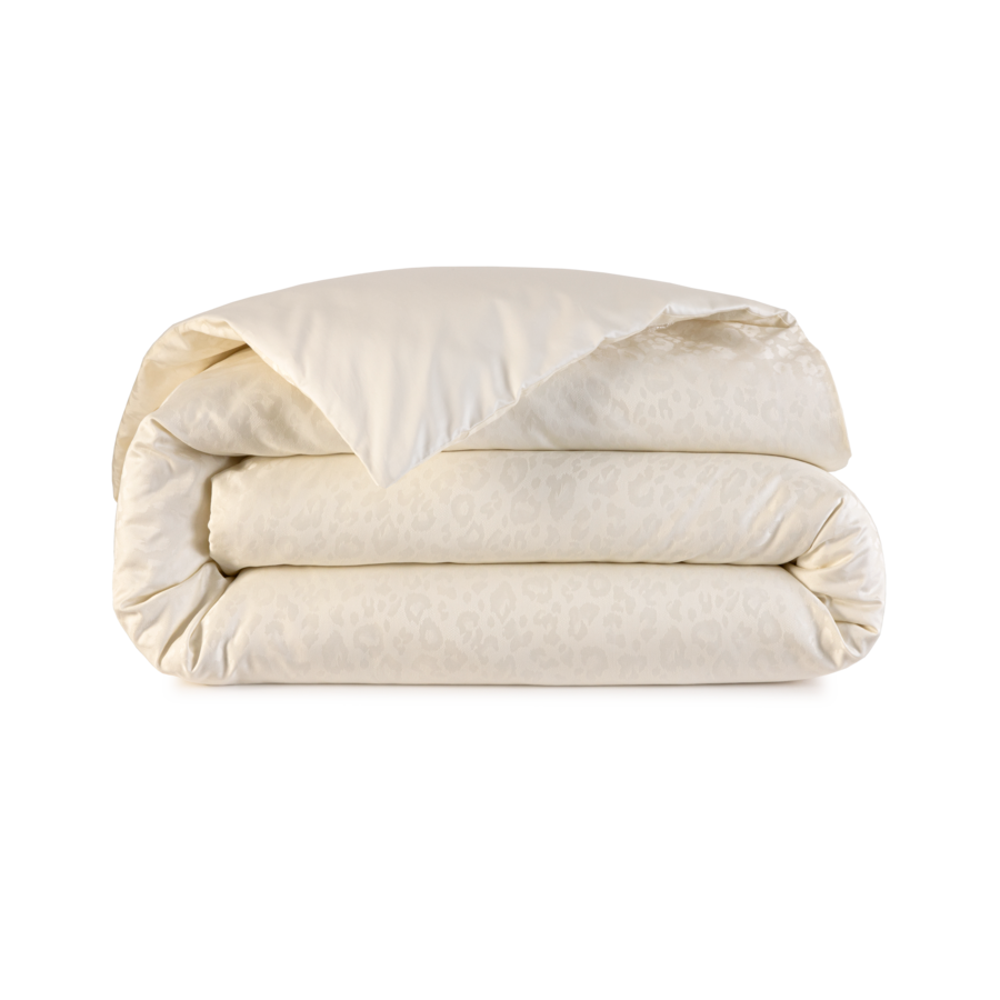 Couette pliée couleur crème à motif discret, présentée sur fond blanc.