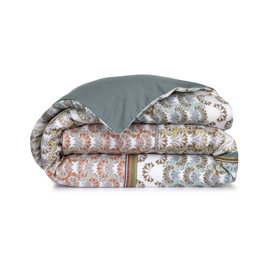 Couette pliée à motifs, ornée de motifs floraux blancs, turquoise et rouille, avec un revers à chevrons turquoise.