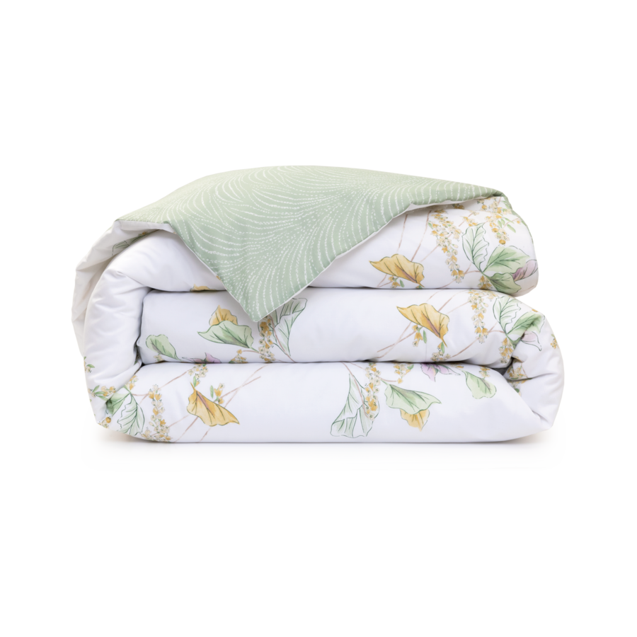 Couette pliée, réversible, à motifs floraux blancs et verts.