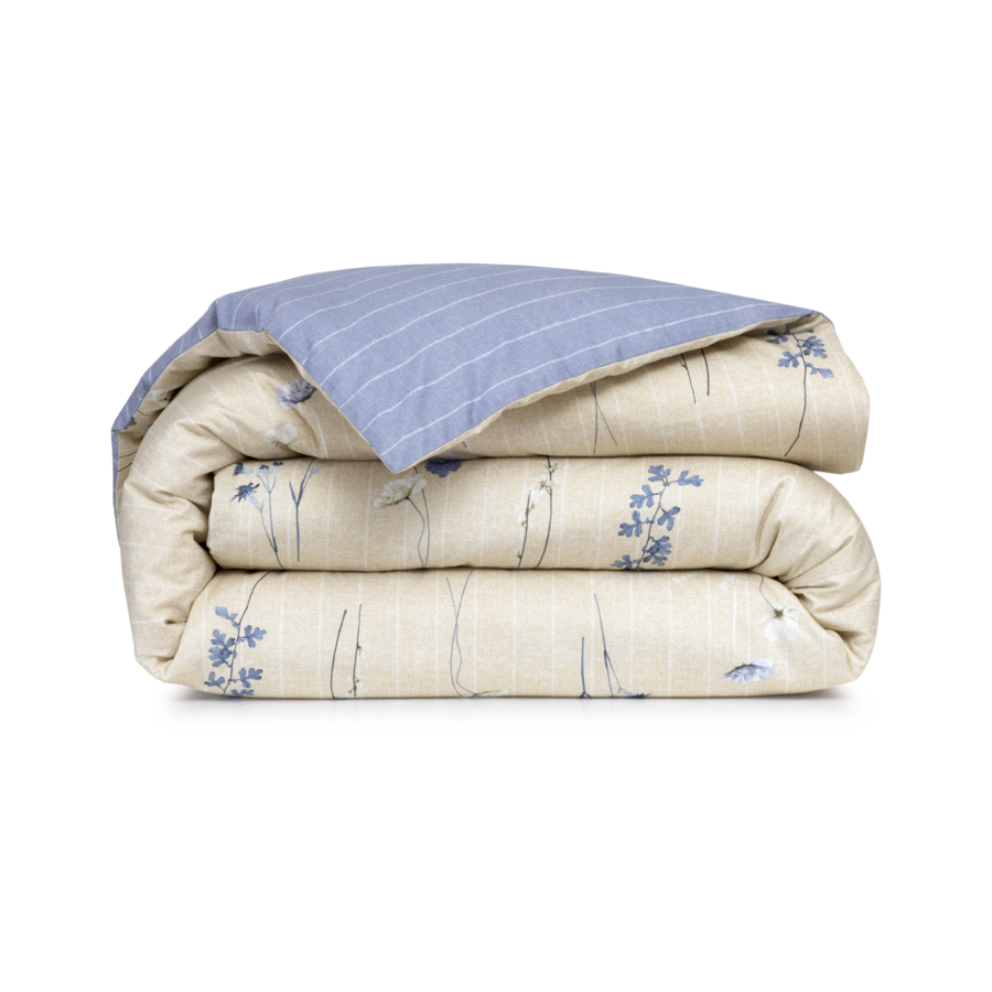 Une couette pliée, à imprimé floral beige d'un côté et à rayures bleu clair de l'autre.
