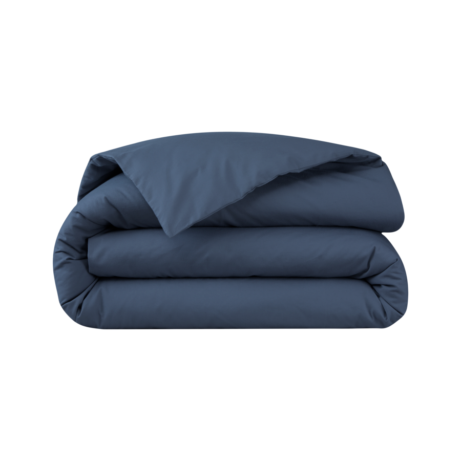 Une housse de couette bleu foncé unie, pliée, isolée sur fond blanc.