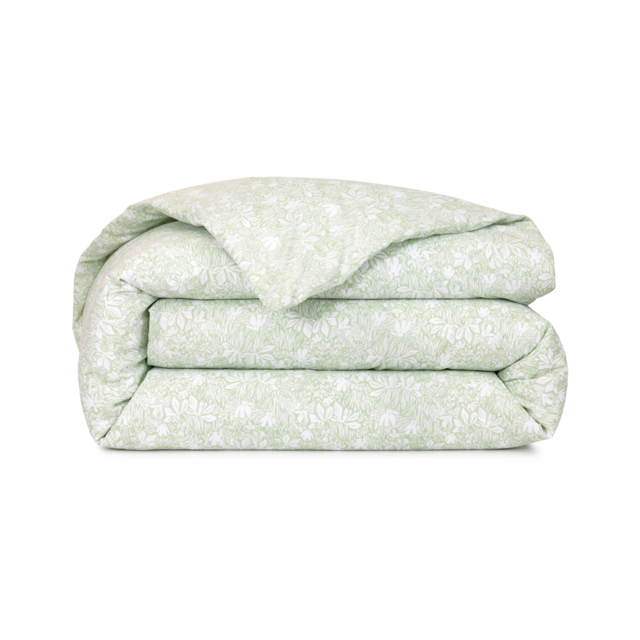 Une housse de couette vert sauge pliée, à motif floral blanc, isolée sur fond blanc.