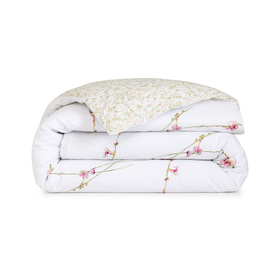 Une couette blanche pliée, ornée d'un délicat motif de branches florales roses et d'un dessous à motifs vert clair sur fond blanc.