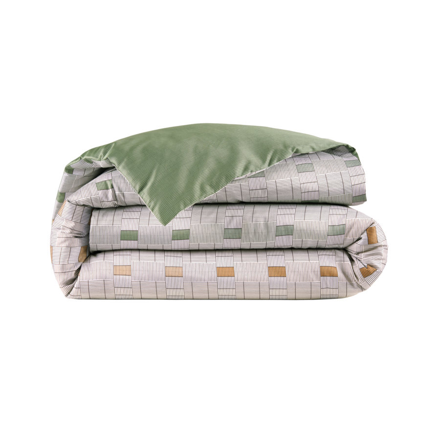 Une housse de couette avec une bordure verte est empilée les unes sur les autres sur un fond blanc.