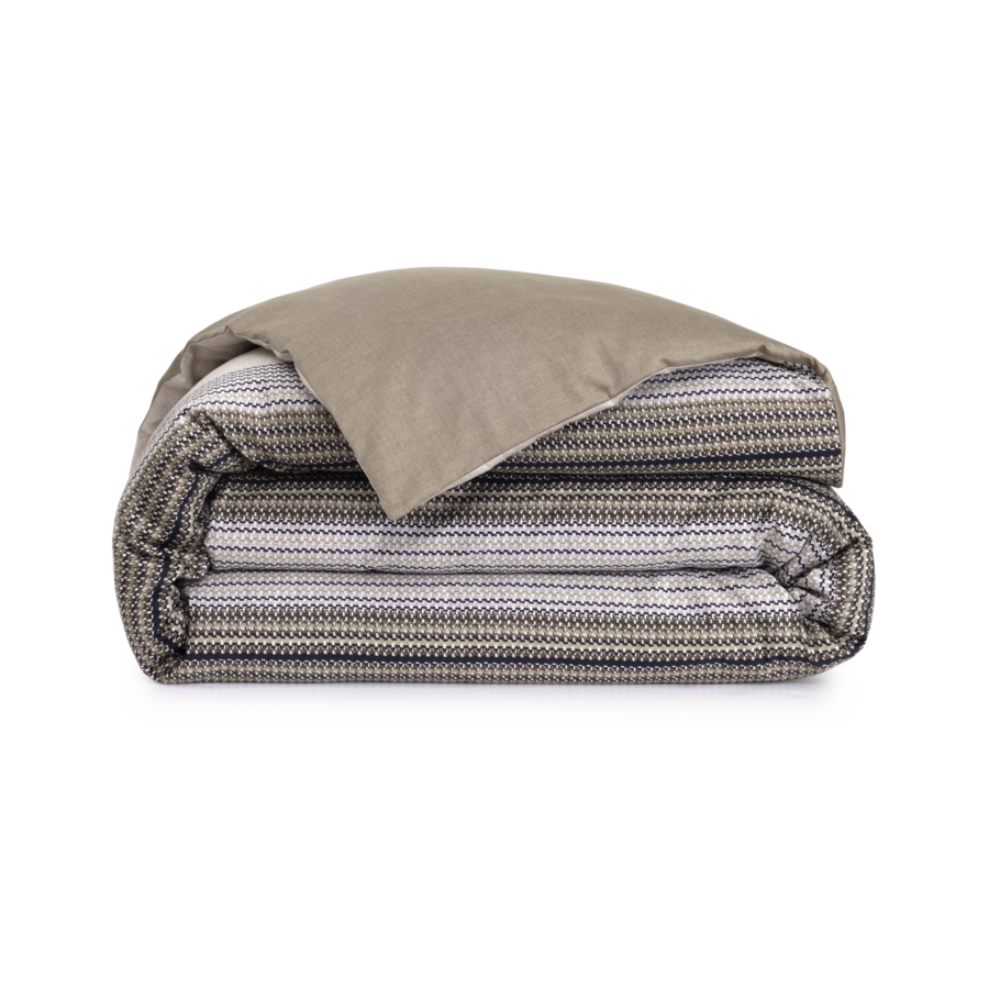 Une couette soigneusement pliée, avec un dessus uni taupe et un dessous à rayures tissées gris anthracite, blanches et marron.