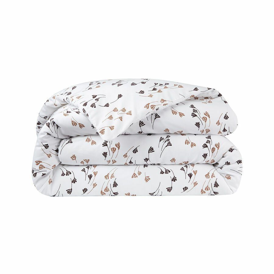 Une housse de couette blanche pliée, ornée d'un motif minimaliste de petites fleurs brunes et foncées éparpillées.