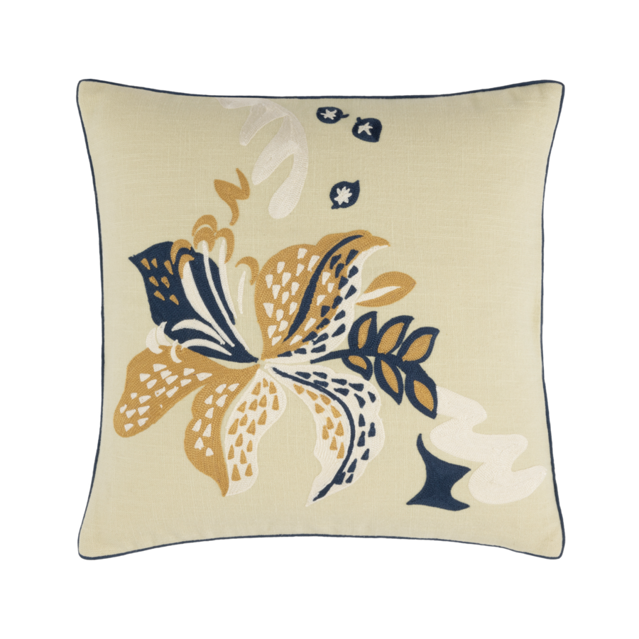 Coussin carré beige orné de broderies florales bleu marine et or, avec un liseré bleu.