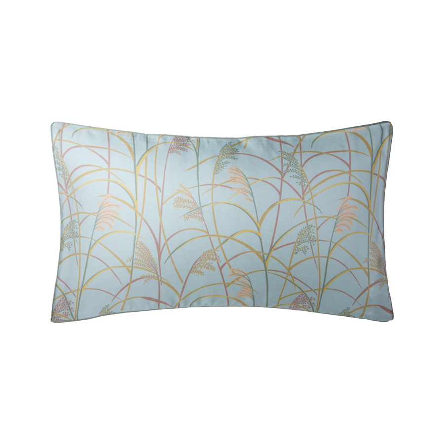 Coussin rectangulaire bleu à motif de roseaux beiges et roses.