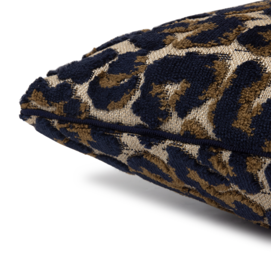 Gros plan sur un coussin à imprimé léopard avec des taches bleu marine, beige et marron.