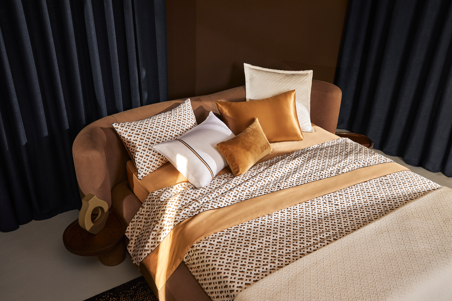 Un lit avec un canapé et des oreillers dessus dans une chambre.