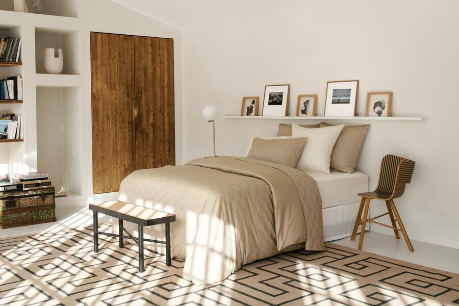 Une chambre avec un lit et un banc dedans