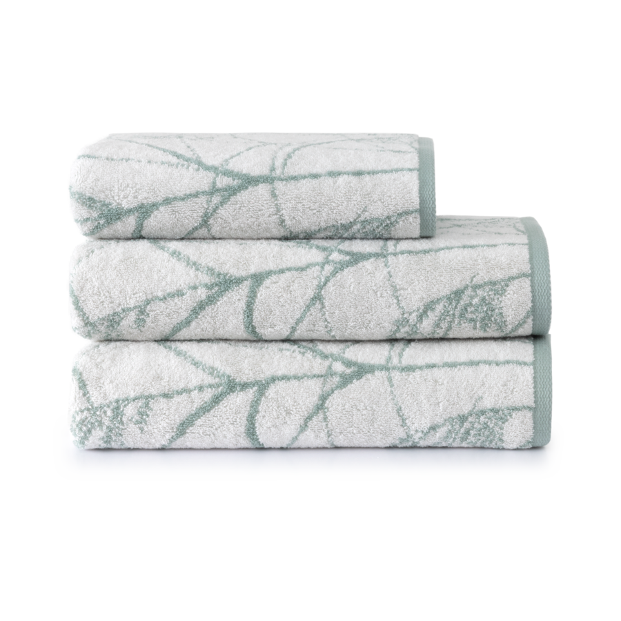 Trois serviettes de bain blanches empilées, avec un motif turquoise et des bordures turquoise.