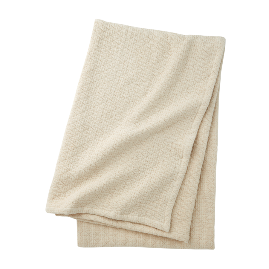 Une couverture texturée couleur crème, pliée et centrée sur un fond blanc uni.