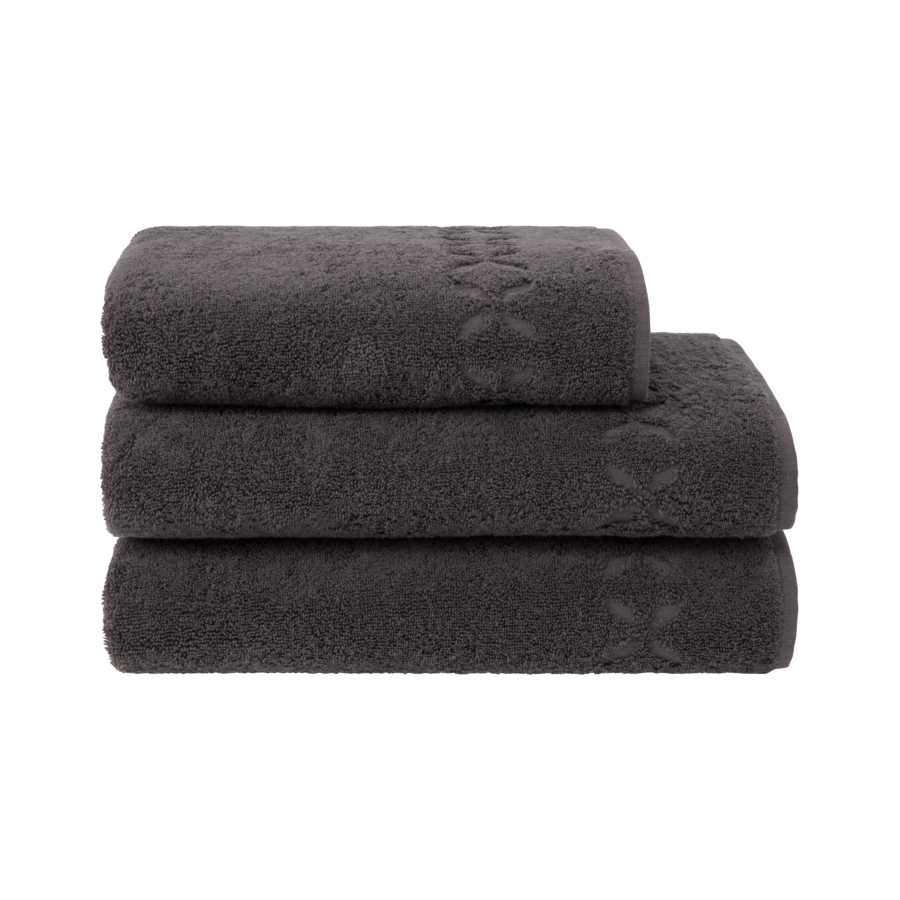 Trois serviettes gris foncé pliées et empilées les unes sur les autres.