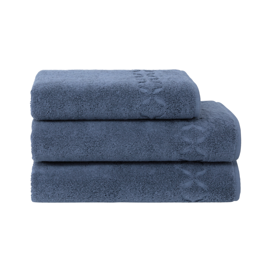 Trois serviettes bleues empilées, à motifs floraux.