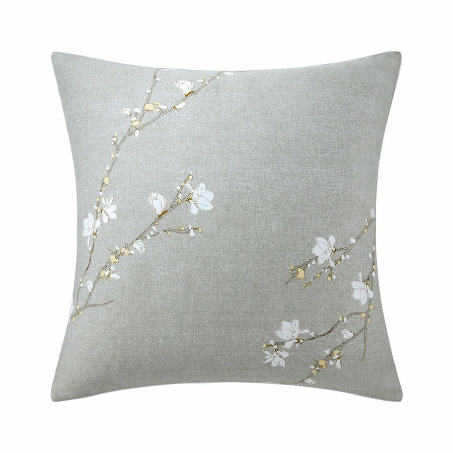 Un coussin gris avec des fleurs blanches dessus