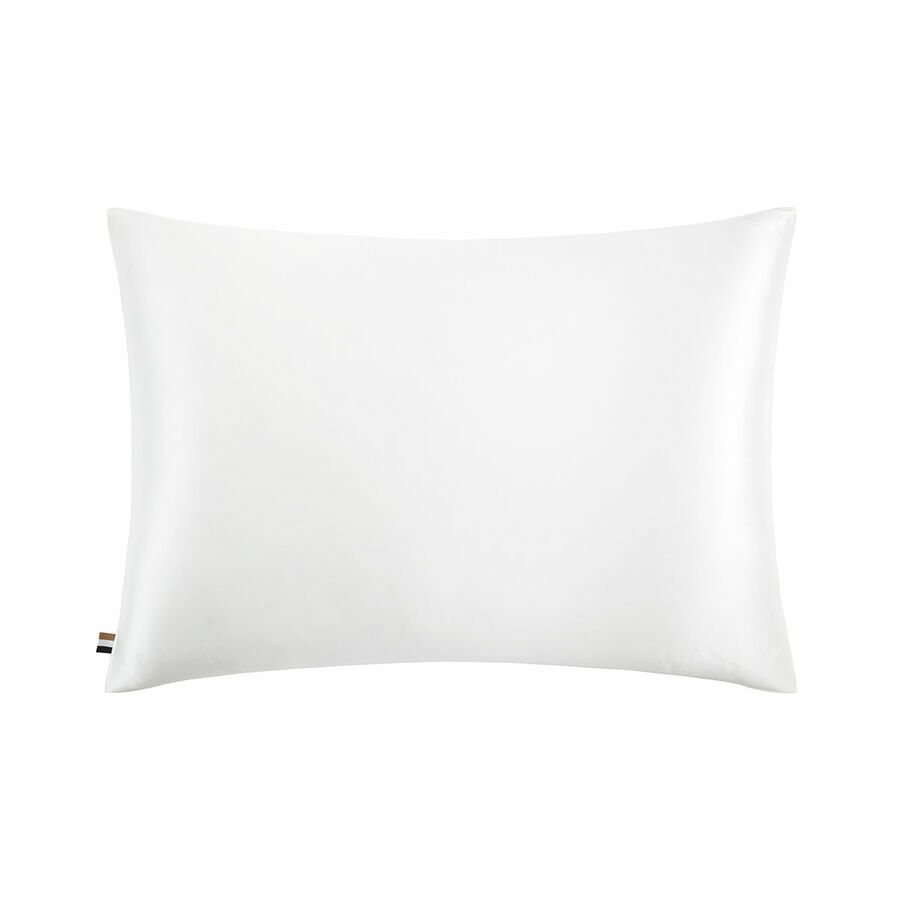 Un oreiller blanc est posé sur une surface blanche.