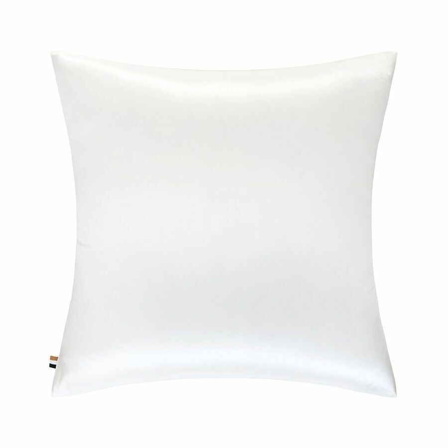 Un oreiller blanc est posé sur une surface blanche.