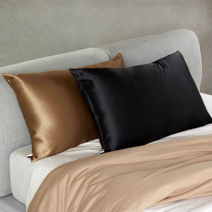 Deux oreillers sont posés sur un lit avec une couette blanche