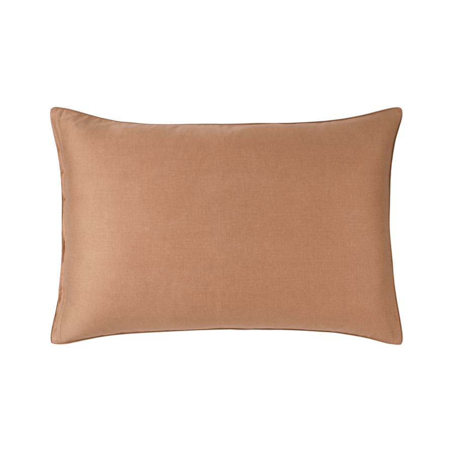 Un oreiller marron est posé sur une surface blanche.