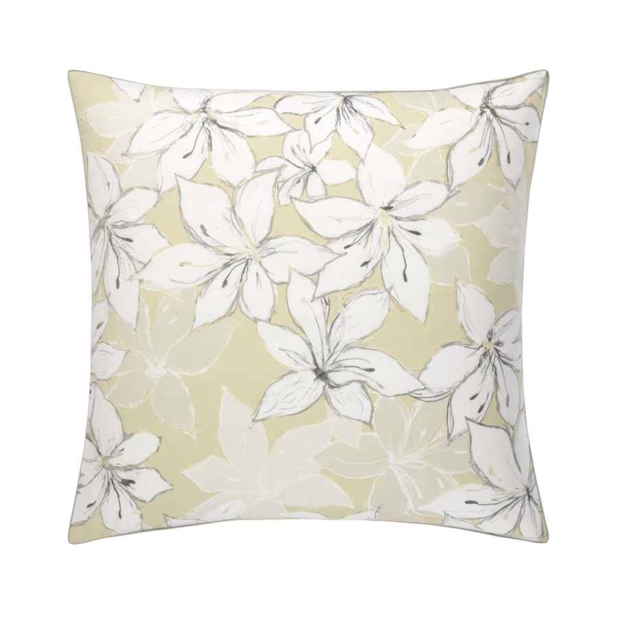 Un coussin avec des fleurs blanches sur fond beige