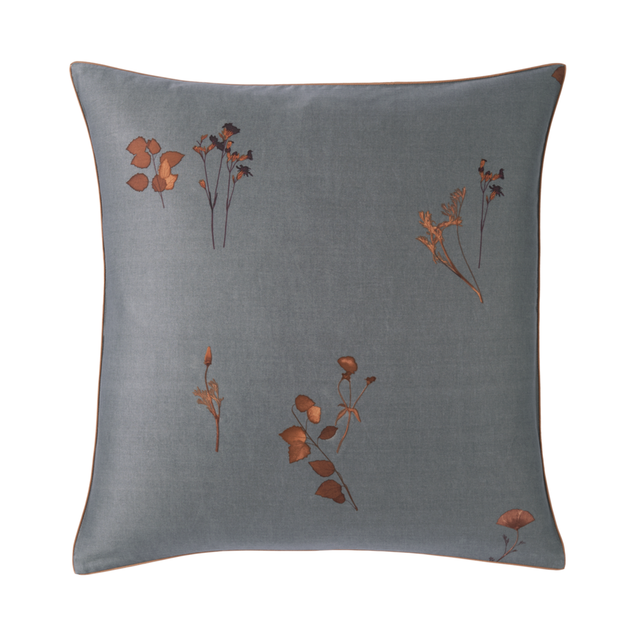 Un coussin gris avec des fleurs cuivrées dessus