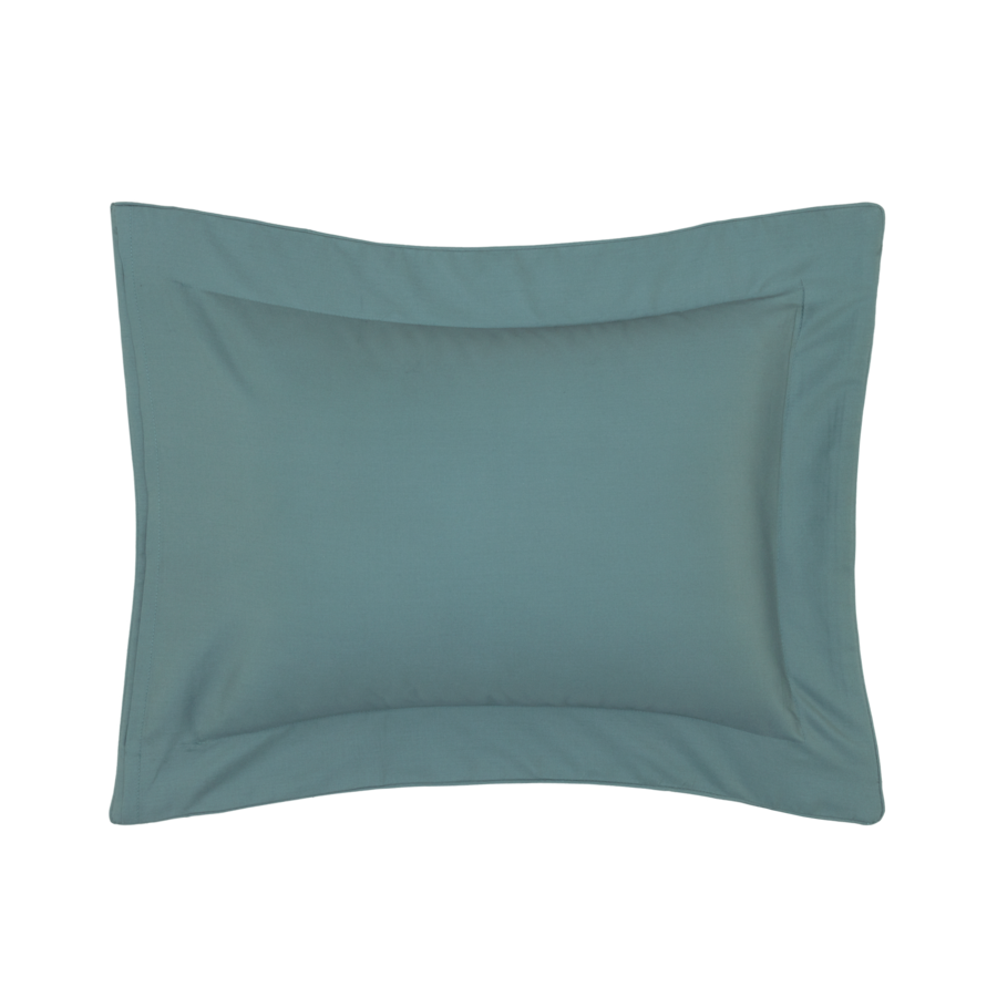 Taie d'oreiller turquoise avec bordure travaillée.