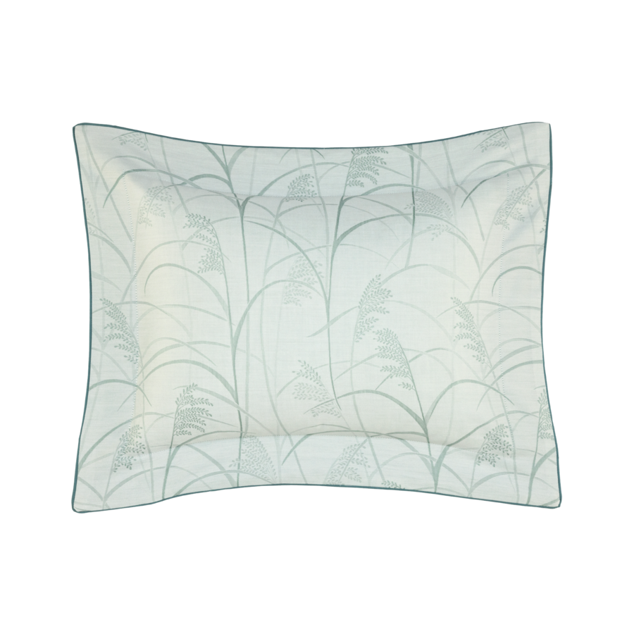 Coussin à motif botanique vert pâle et bordure vert foncé.