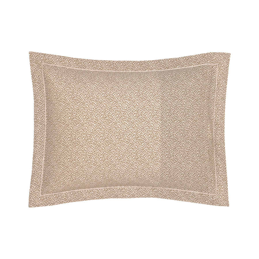 Coussin beige à petits motifs texturés et bordure blanche.