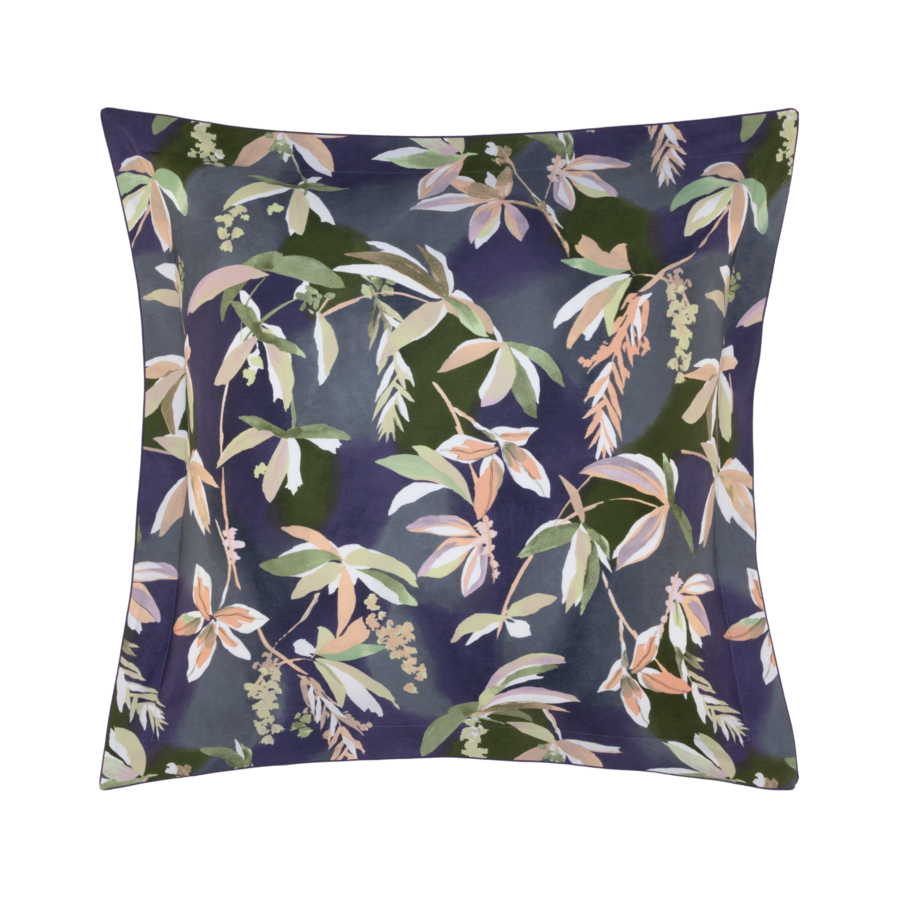 Coussin carré à motif floral bleu foncé, orné de feuilles vertes, pêche et blanches.