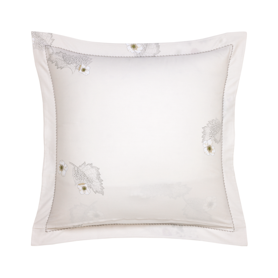 Coussin carré blanc à broderie florale, encadré d'une bordure cousue.