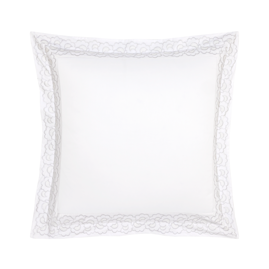 Coussin carré blanc avec bordure en dentelle.