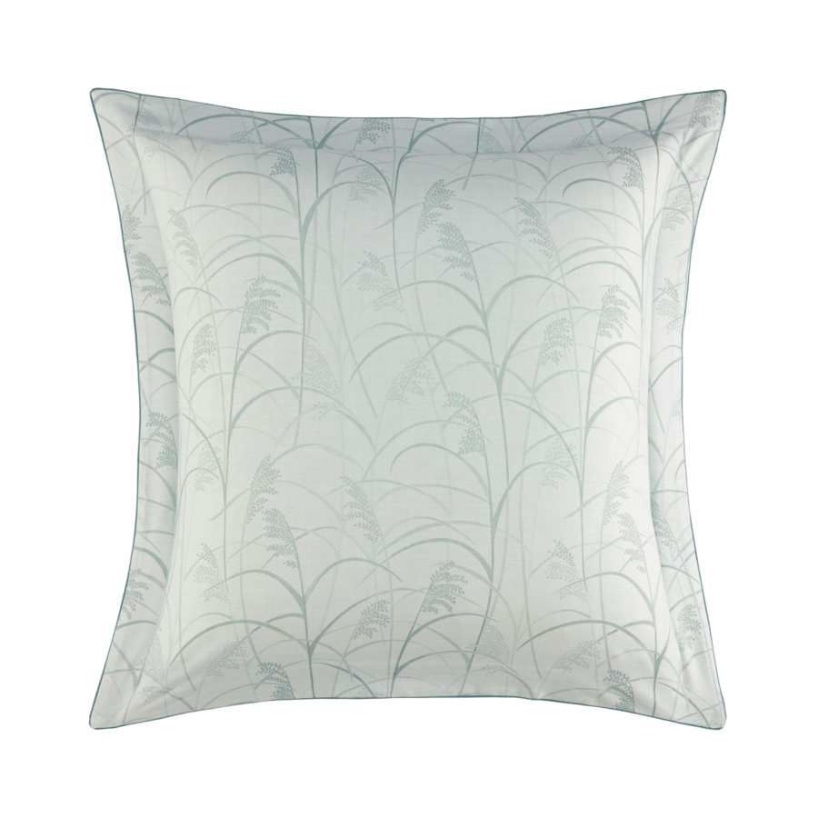 Coussin carré décoratif à motif floral bleu clair sur fond blanc.