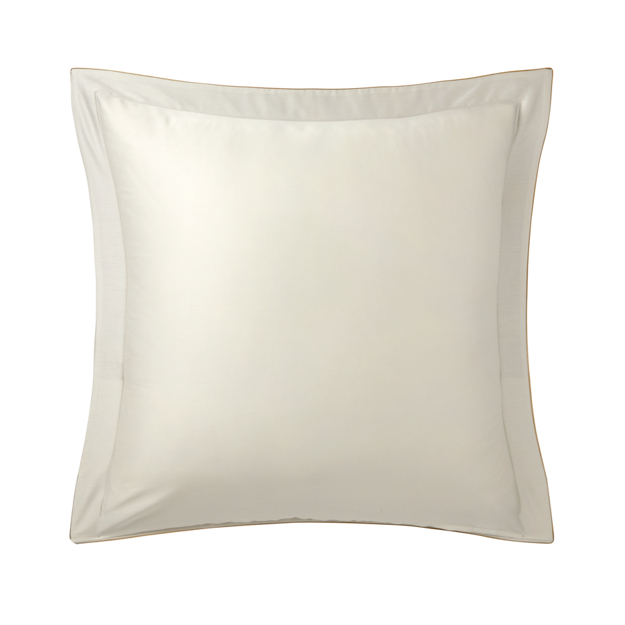 Un oreiller blanc est posé sur une surface blanche.