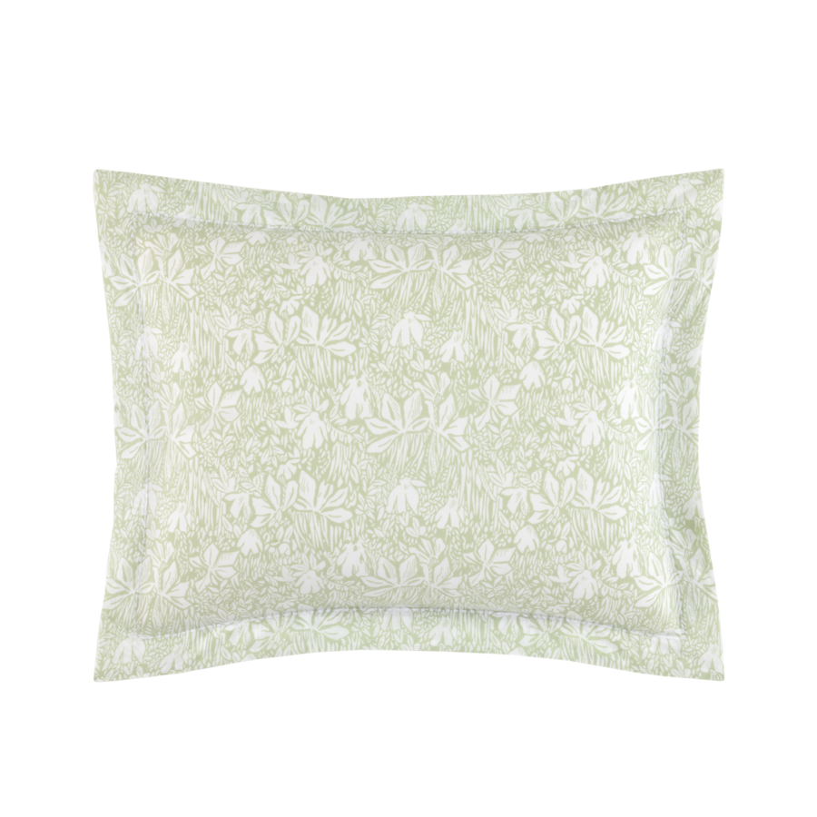 Une taie d'oreiller rectangulaire ornée d'un motif botanique de feuilles blanches et vert sauge clair, et d'une bordure décorative.