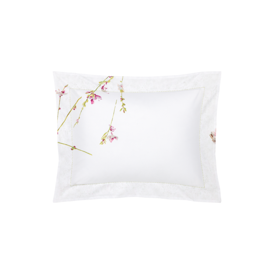 Une taie d'oreiller rectangulaire blanche ornée d'un délicat motif floral rose et vert sur le côté gauche et les bords.