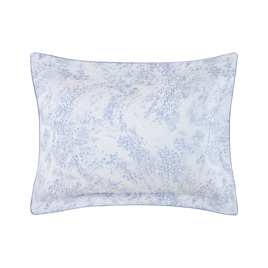 Une taie d'oreiller rectangulaire à motif abstrait tourbillonnant bleu clair et blanc, bordée d'un passepoil bleu clair uni.