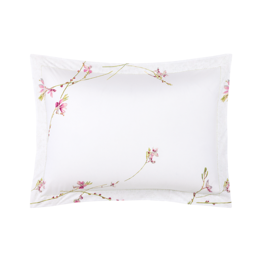 Une taie d'oreiller blanche ornée de délicats motifs floraux roses brodés sur les bords.